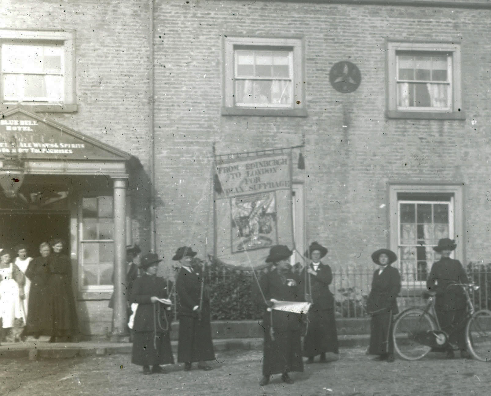 The Blue Bell Hotel in 1912, with suffrage marchers passing